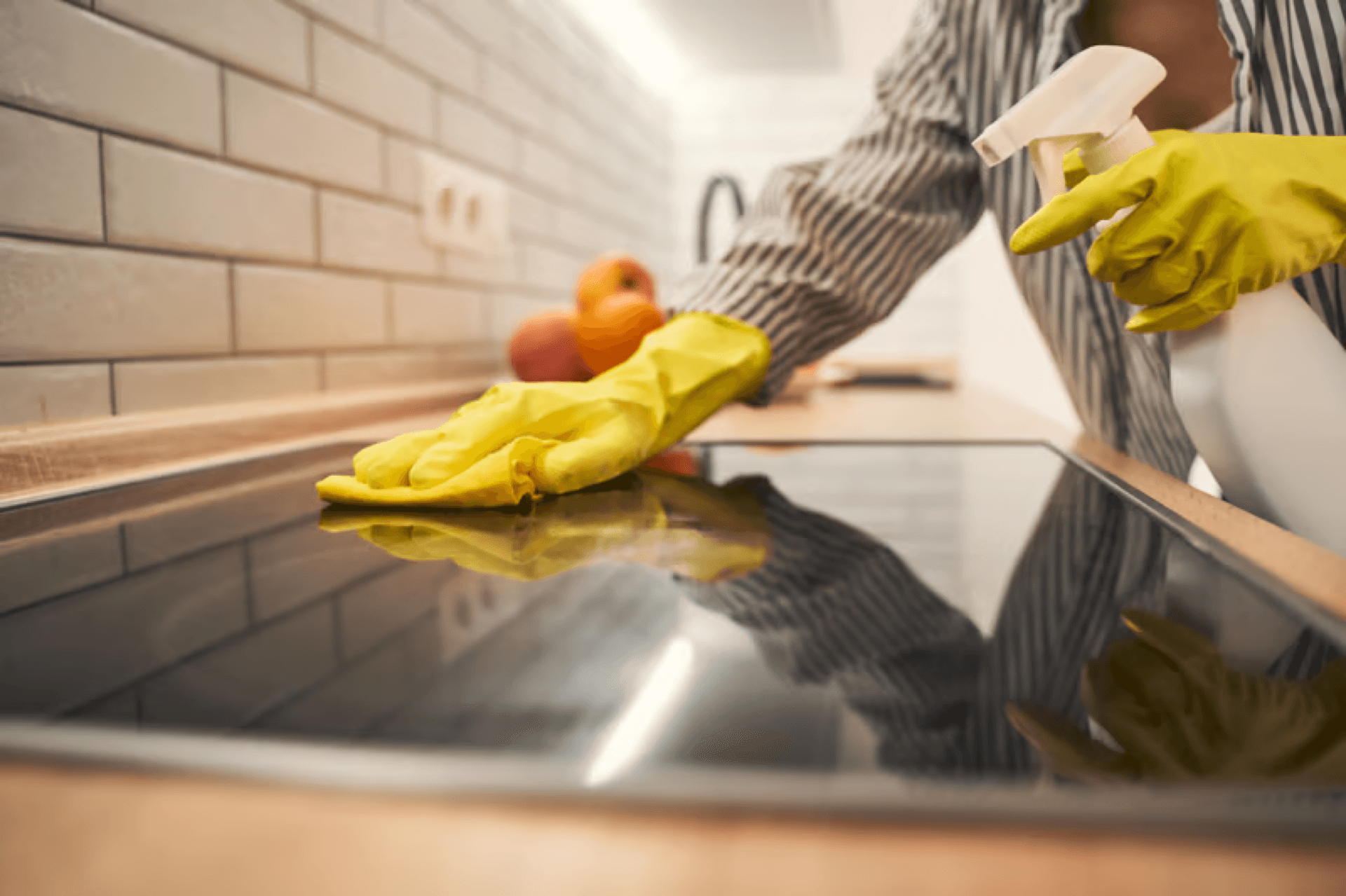 Gloved hand deep cleaning a kitchen cooktop
